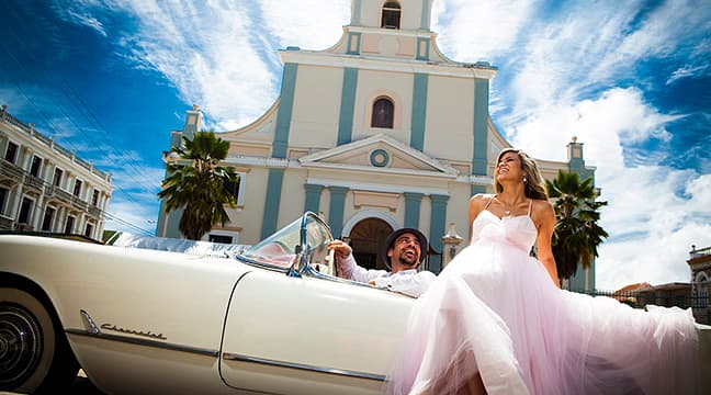 Couple in a vintage car in Arecibo Cathedral
