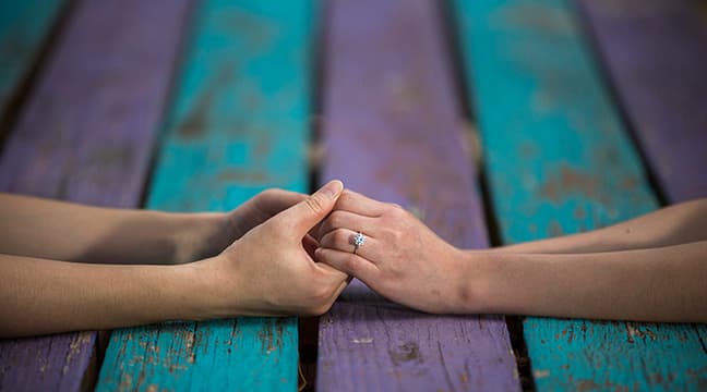 Hands together with engagement ring