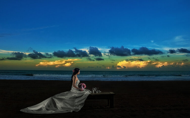 Bride in a bench during sunset at St. Regis Bahia Beach Resort